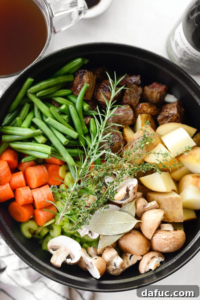 Adding fresh herbs like thyme, rosemary, and bay leaves to the stew
