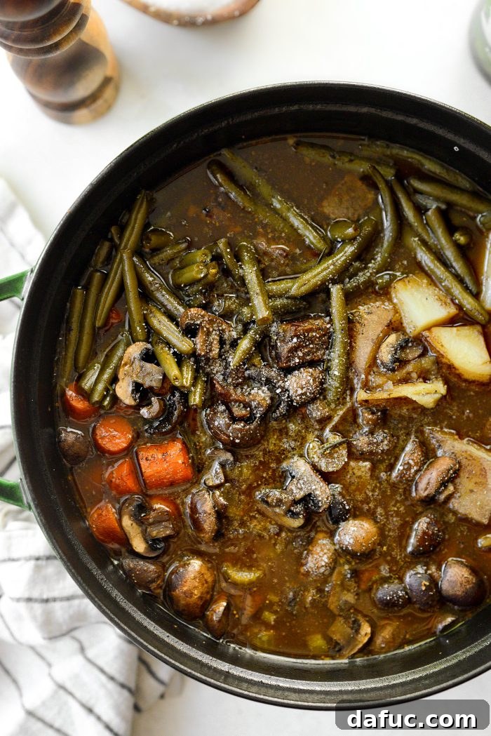 Removing herb sprigs from oven braised beef stew before serving