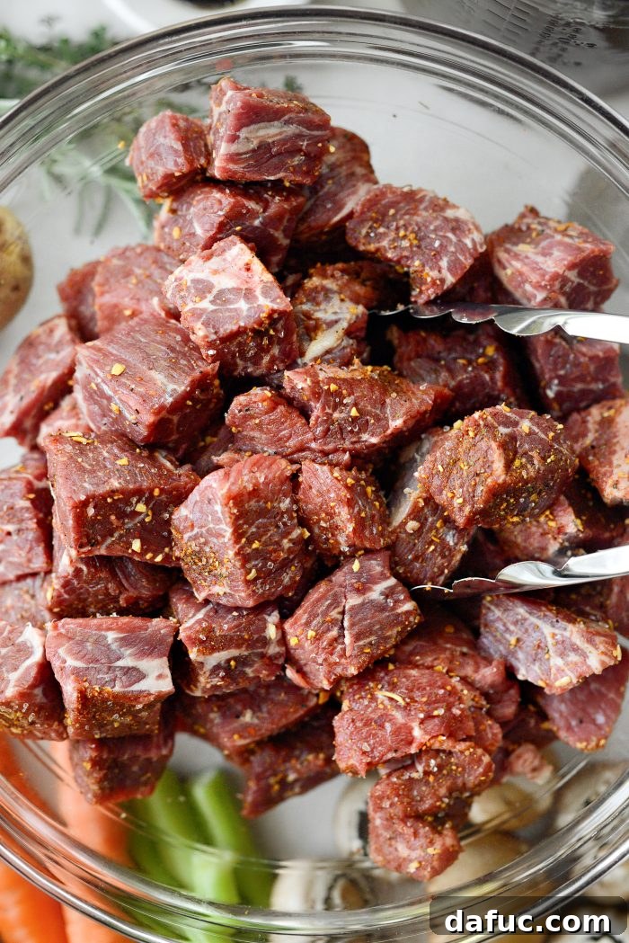 Tossing cubed beef with steak seasoning to ensure even coating