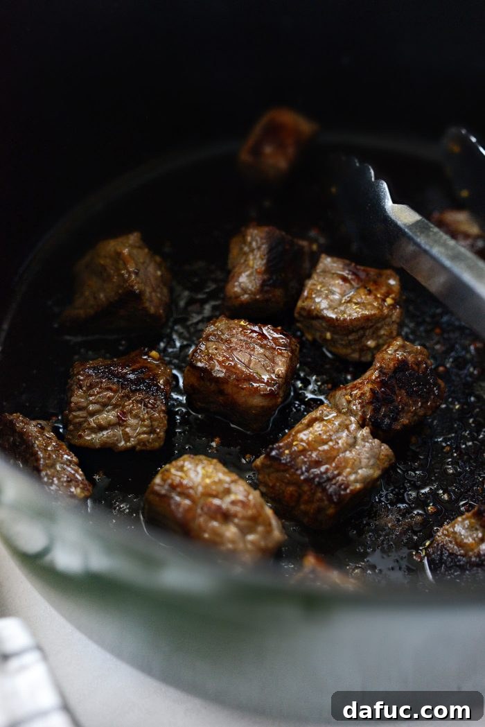 Perfectly seared beef cubes in the pot, showcasing a rich brown color