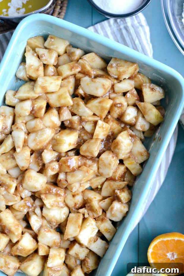 The apple and pear fruit filling spread evenly in a glass baking dish, ready for topping