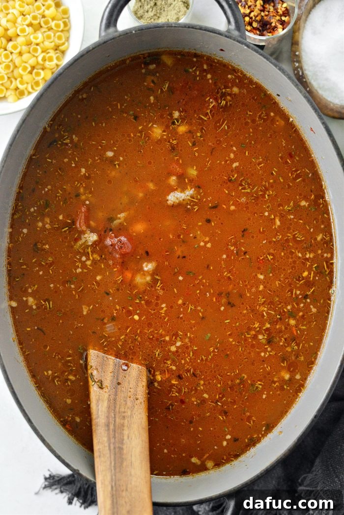 Covering the Dutch oven to simmer the soup for 30 minutes, allowing flavors to deepen