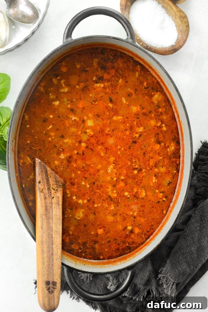 Removing the parmesan rind and seasoning the soup with salt and freshly ground black pepper