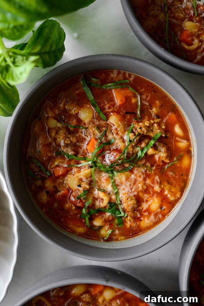 Close-up view of a steaming bowl of Italian Sausage White Bean Soup, ready to be enjoyed