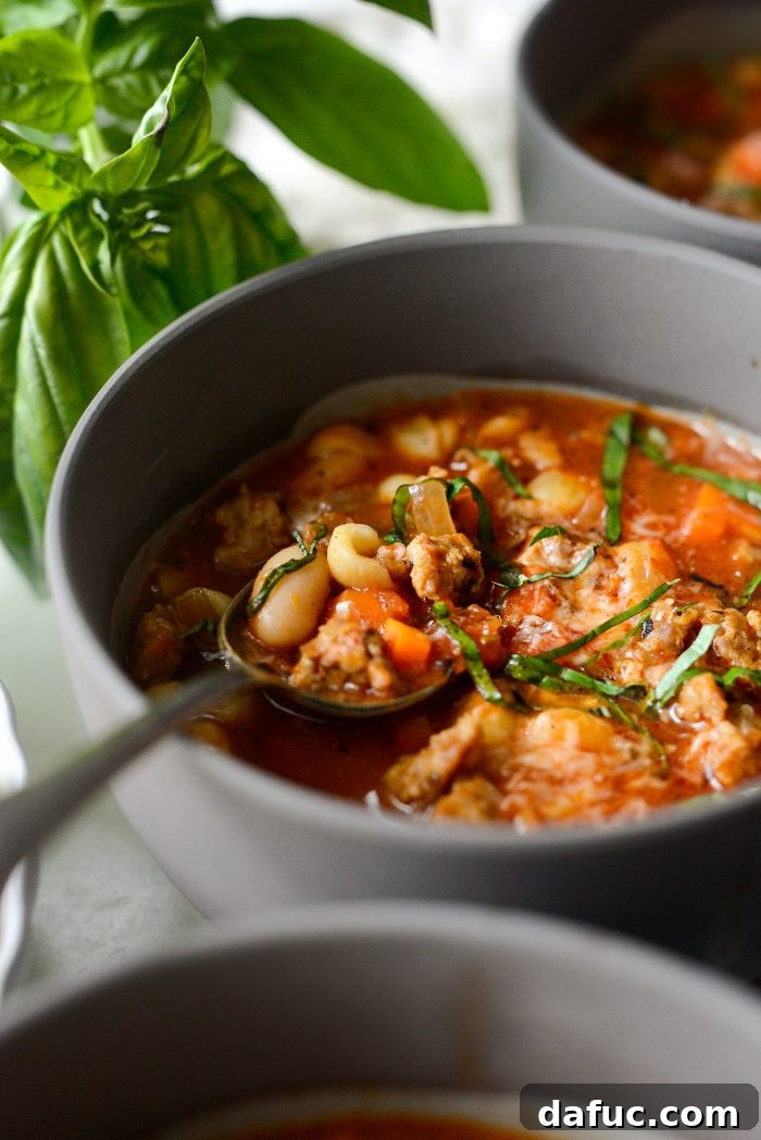 A large pot of Italian Sausage White Bean Soup on a stovetop, ready to be served or stored