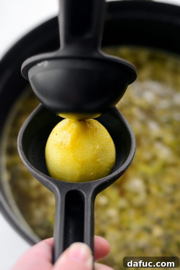 Bright Lemon Rosemary Chicken Noodle Soup 12 Squeezing fresh lemon juice into the finished soup
