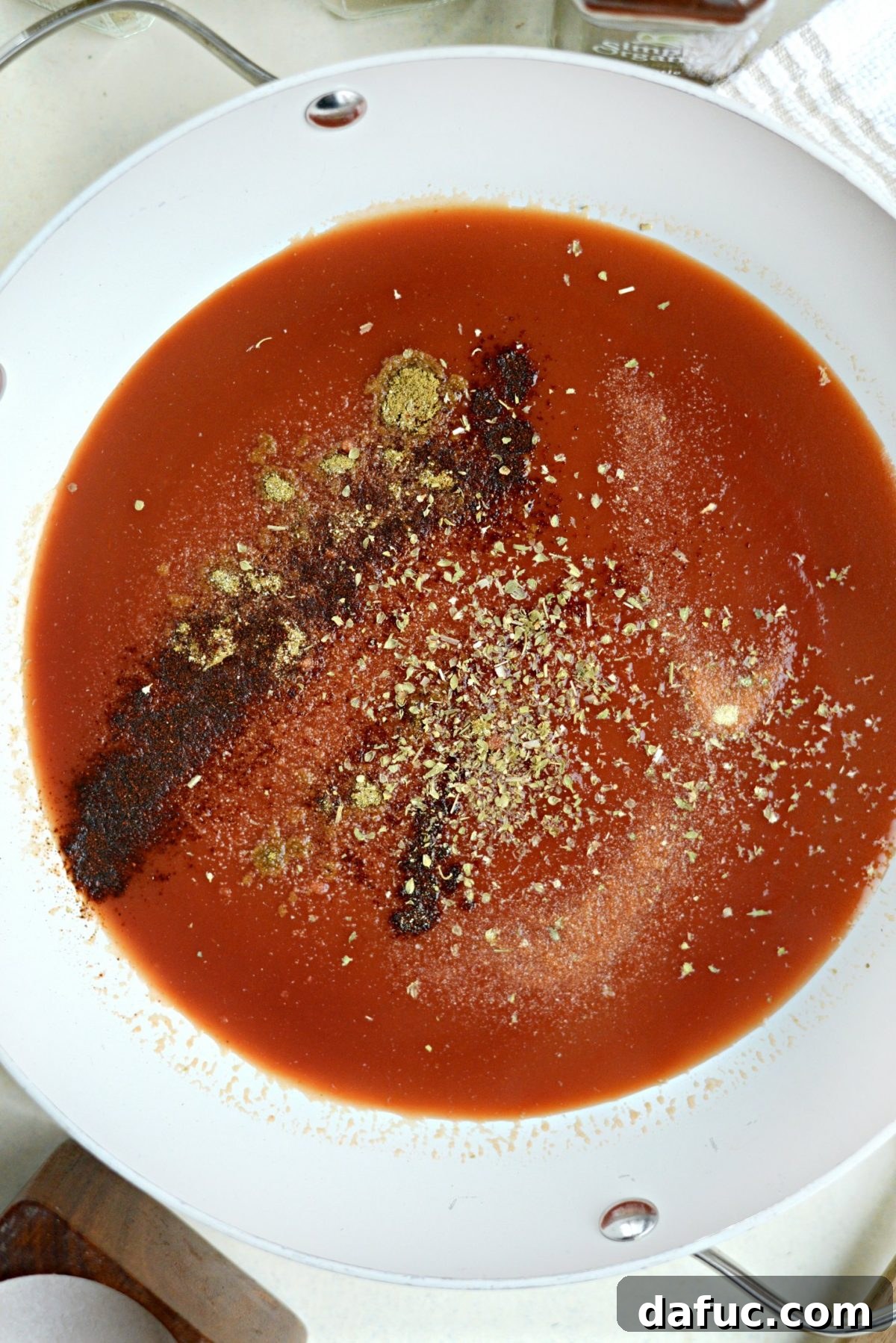 Tomato sauce and spices simmering in a pan