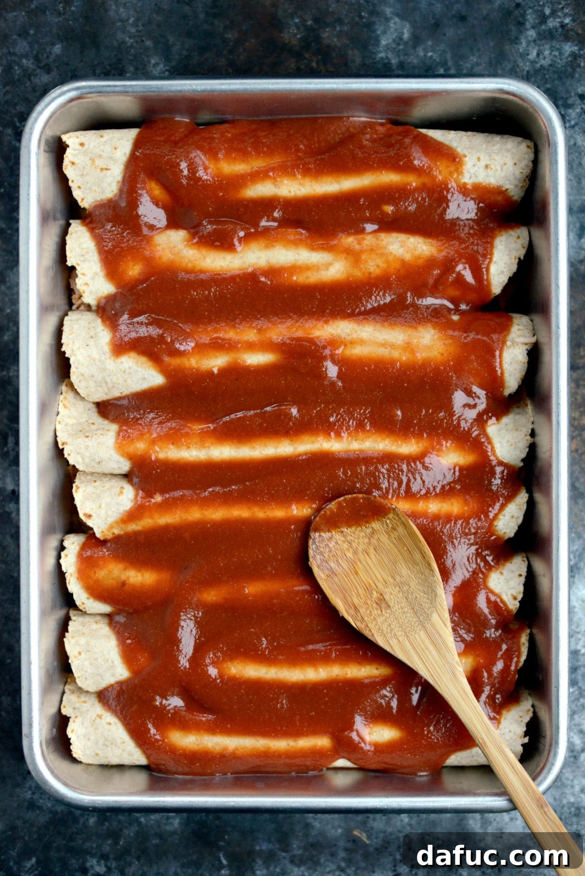 Fiesta Chicken and Rice Enchiladas 8 Spreading remaining enchilada sauce over rolled enchiladas in a baking dish