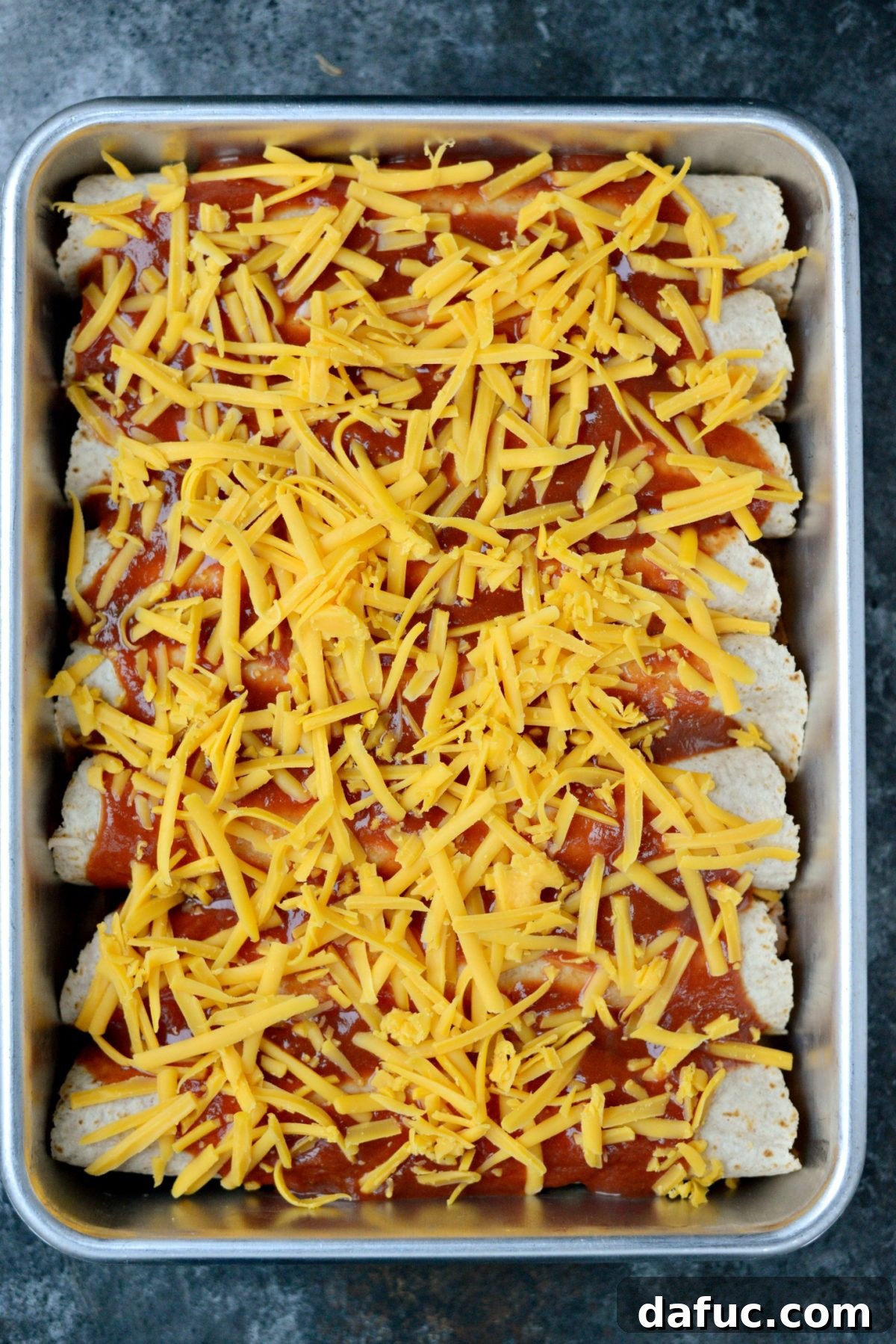 Fiesta Chicken and Rice Enchiladas 9 Sprinkling grated cheddar cheese over enchiladas before baking