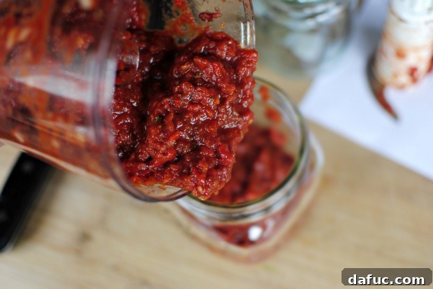 Roasted red pepper pizza sauce stored in a glass container with a lid