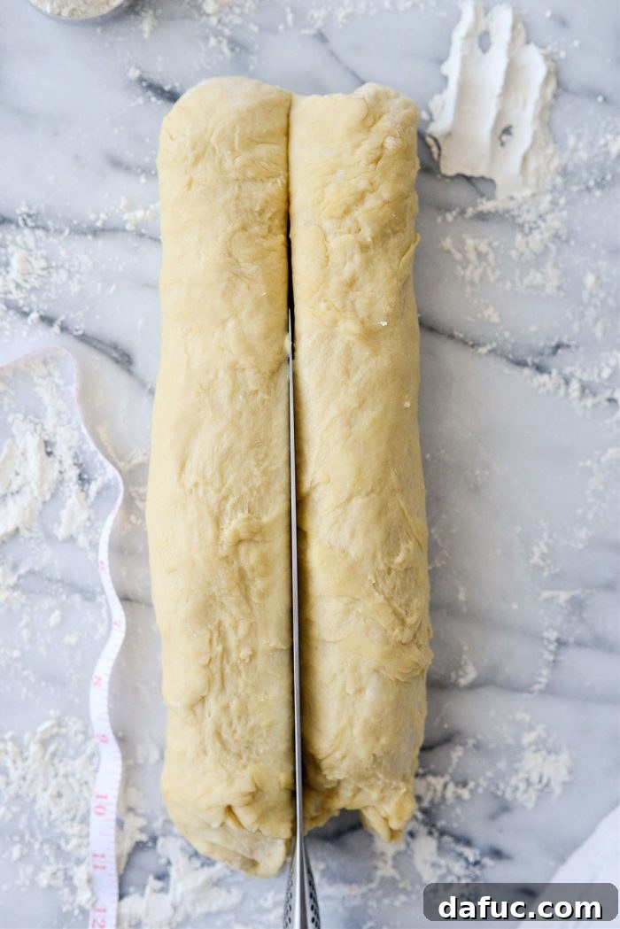 Irresistibly Easy Homemade Rolls 19 Dough log being divided in half lengthwise with a knife