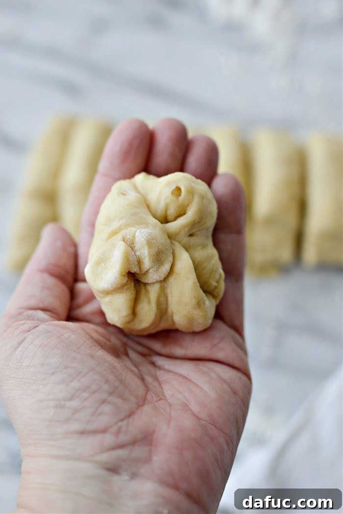Irresistibly Easy Homemade Rolls 21 Gathering and pinching the ends of a dough piece to form a smooth surface