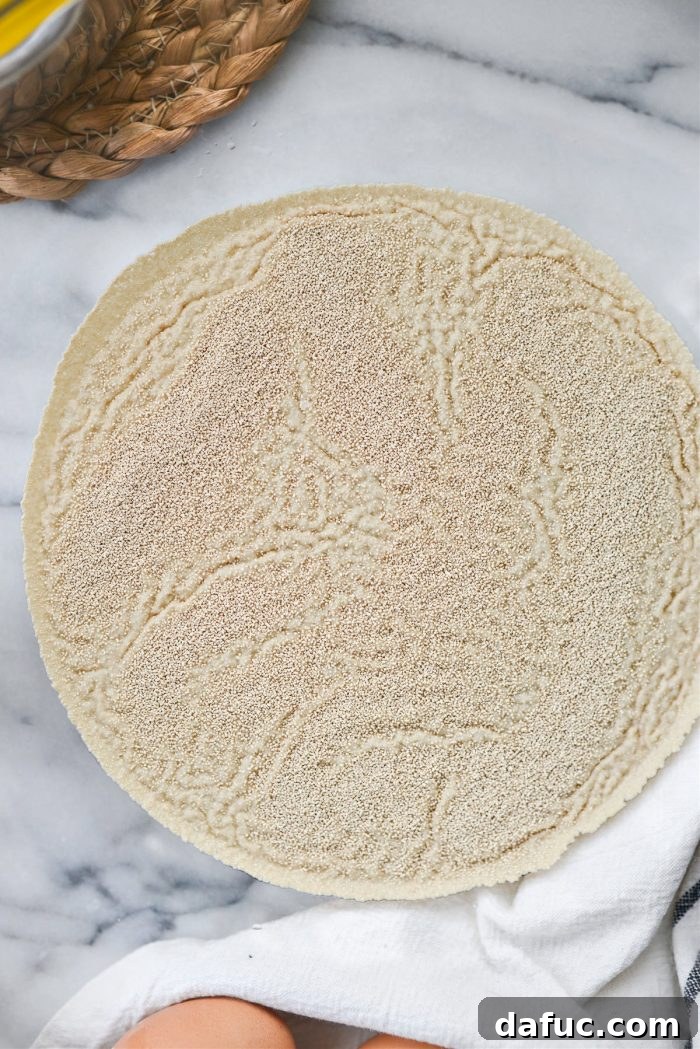 Irresistibly Easy Homemade Rolls 5 Active dry yeast being sprinkled over warm water in a bowl