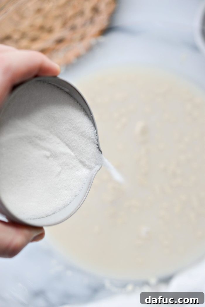 Irresistibly Easy Homemade Rolls 8 Granulated sugar being added to the bloomed yeast and water mixture