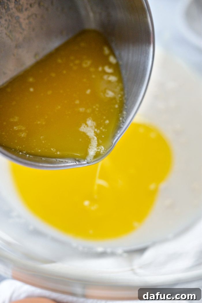 Irresistibly Easy Homemade Rolls 9 Melted butter being poured into the yeast, water, and sugar mixture