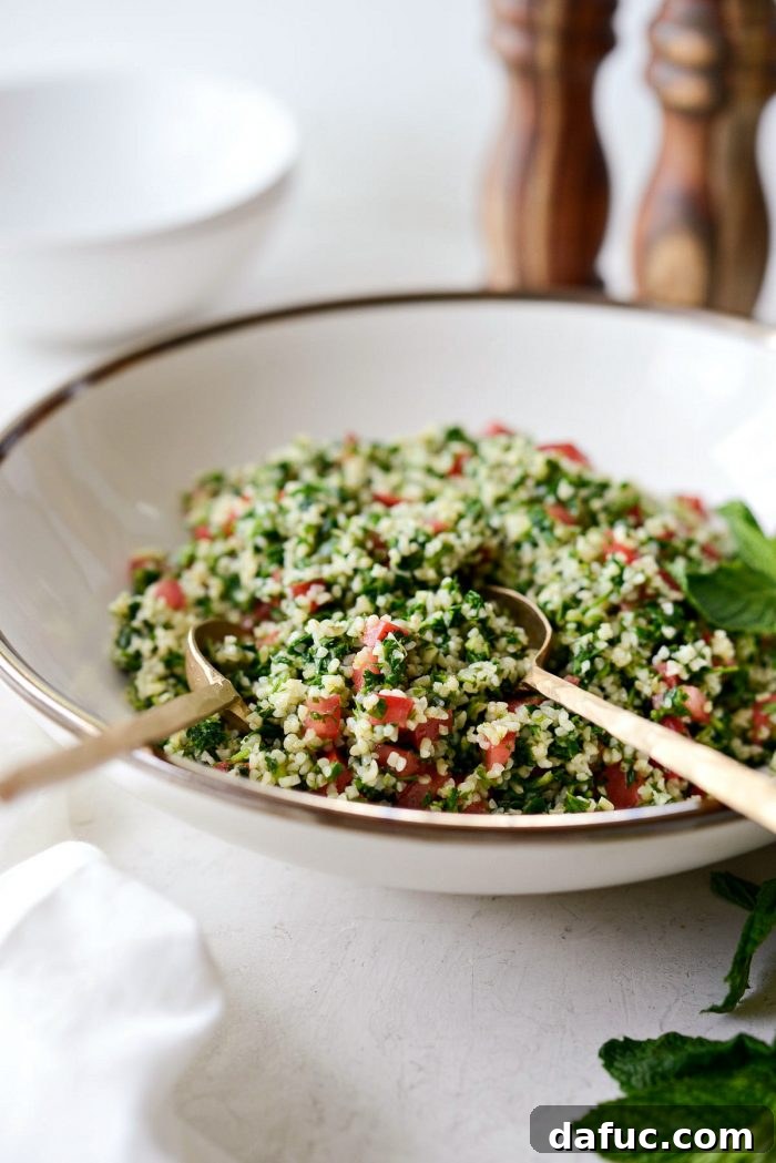 Perfect Homemade Tabbouleh 14 Gold spoons gracefully resting in a generous bowl of homemade tabbouleh, highlighting its inviting texture and fresh ingredients.