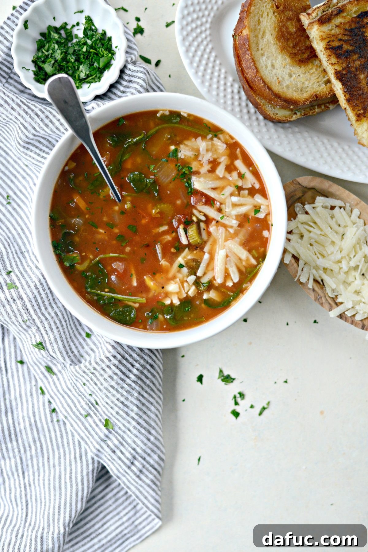 Velvety Tomato Spinach Soup 12 A beautifully presented bowl of Tomato Florentine Soup with a side of gourmet grilled cheese.