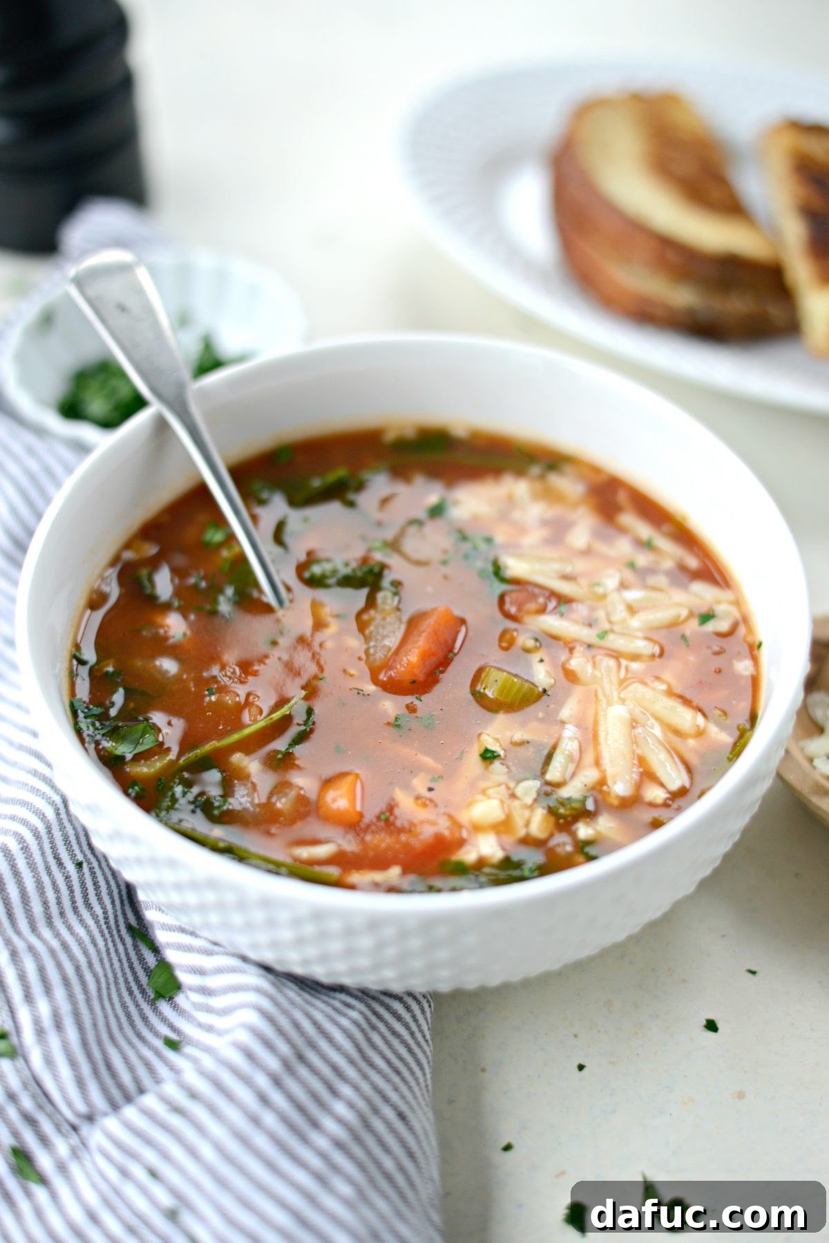 Velvety Tomato Spinach Soup 13 A rustic and inviting overhead shot of Tomato Florentine Soup in a bowl, with a spoon resting inside.