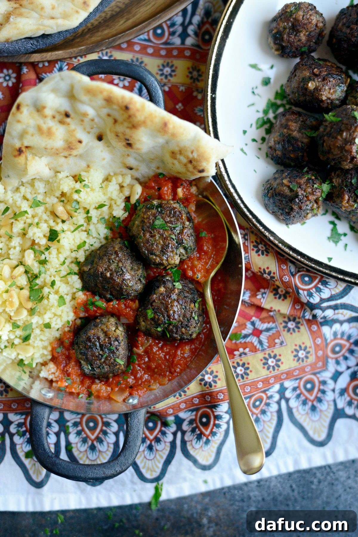 A complete meal of African Spiced Lamb Meatballs with Roasted Red Pepper Harissa, couscous, and roasted vegetables.