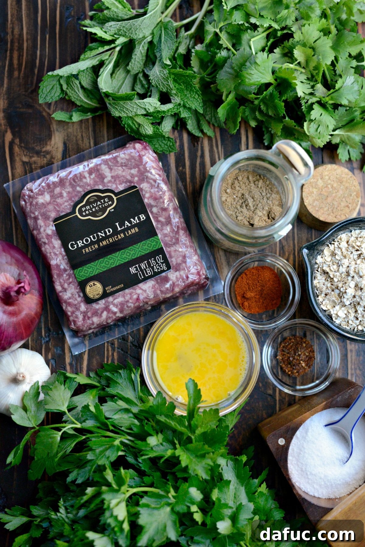 All the ingredients for North African Spiced Lamb Meatballs and Roasted Red Pepper Harissa laid out on a kitchen counter.