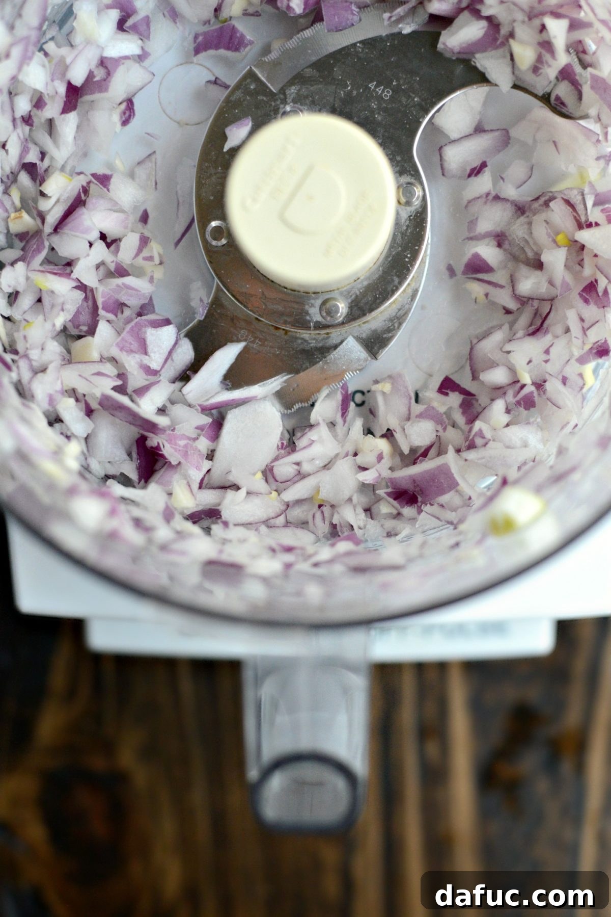 Red onion being pulsed in a food processor for the lamb meatballs.