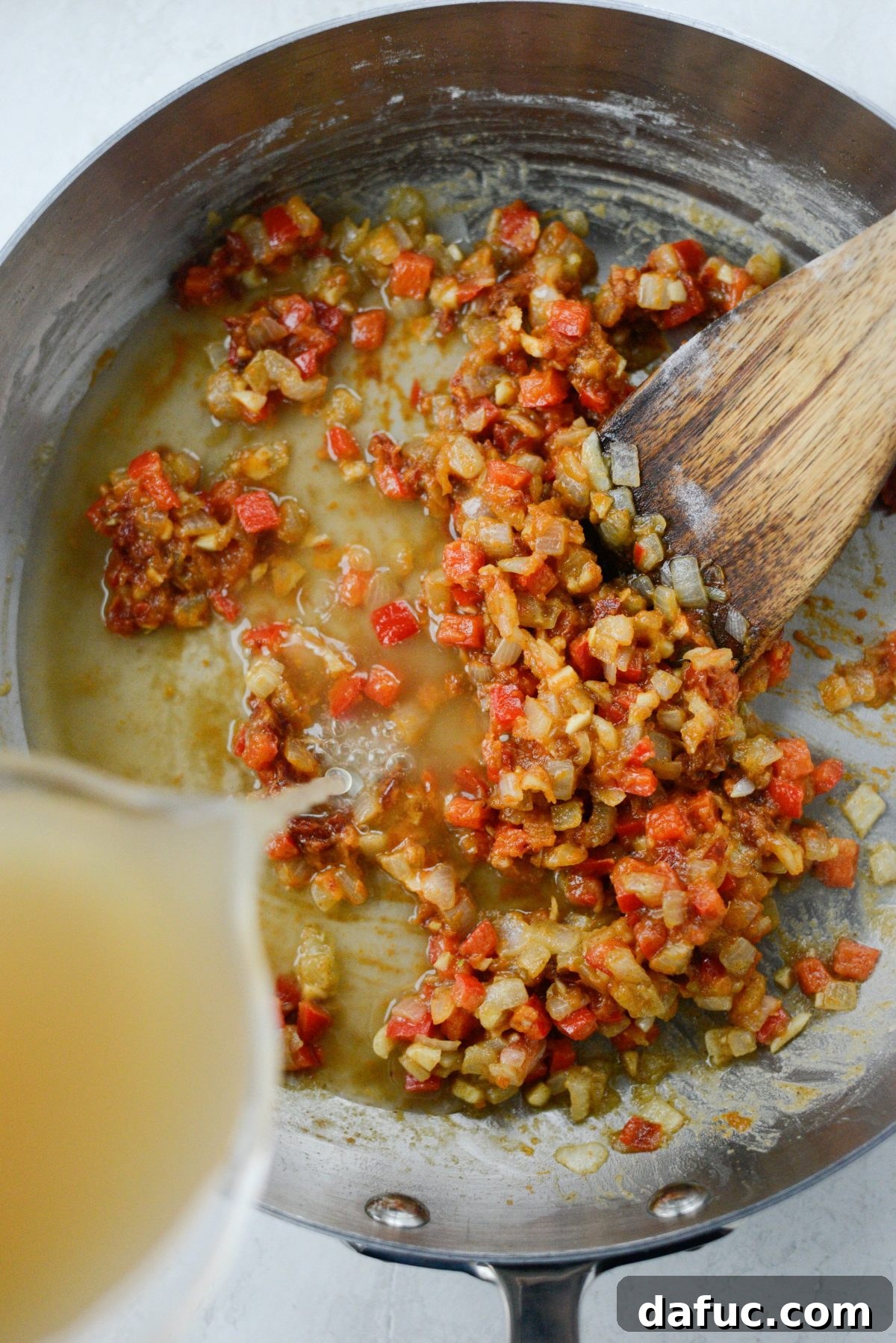 Minced chipotle peppers and adobo sauce being added to the roux