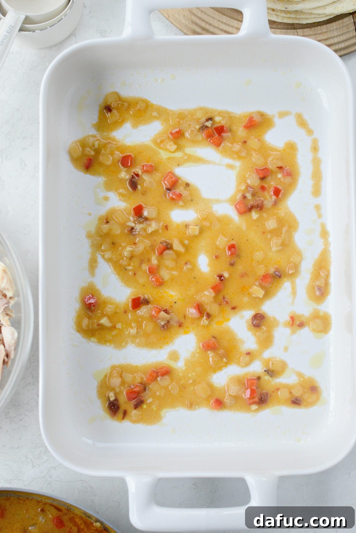Shredded chicken being mixed with creamy chipotle sauce in a bowl