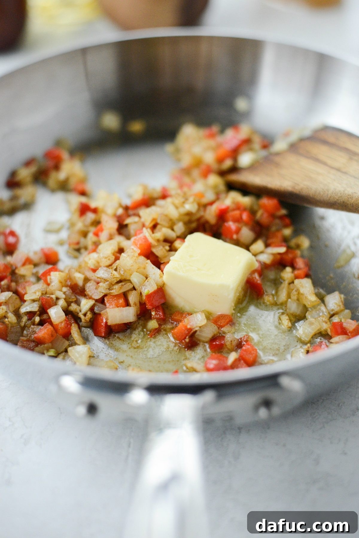 Stirring aromatic spices into the sauce base for Lighter Chicken Enchiladas