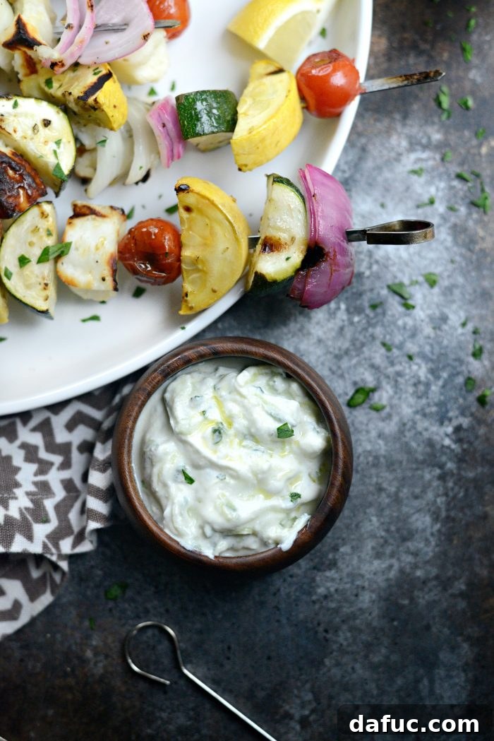 Creamy Homemade Tzatziki 2 Homemade Tzatziki - A bowl of creamy white tzatziki dip garnished with fresh mint and a drizzle of olive oil, ready to be served.