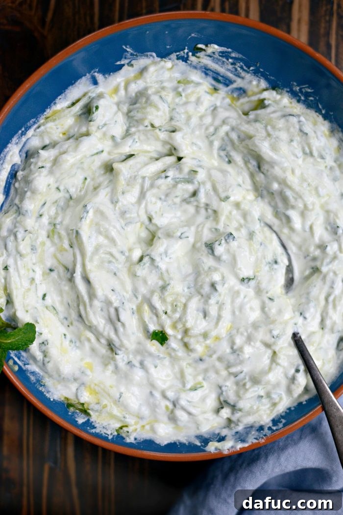 Creamy Homemade Tzatziki 7 Homemade Tzatziki - A close-up shot of the finished tzatziki dip in a bowl, showing its creamy texture and fresh herbs, ready for serving.