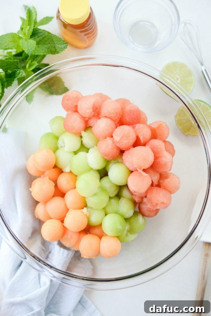 Honey Lime Mint Melon Delight 5 Melon balls in a large glass bowl, showcasing vibrant colors