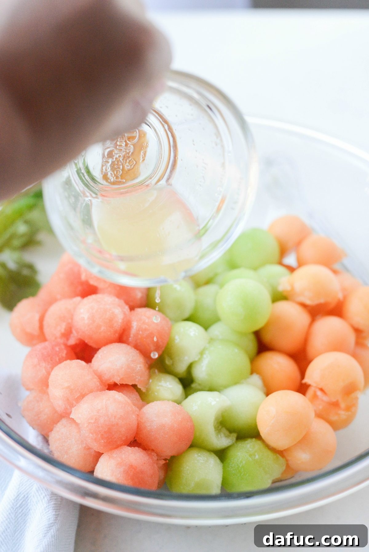 Honey Lime Mint Melon Delight 6 Pouring citrus honey dressing over mixed melon balls