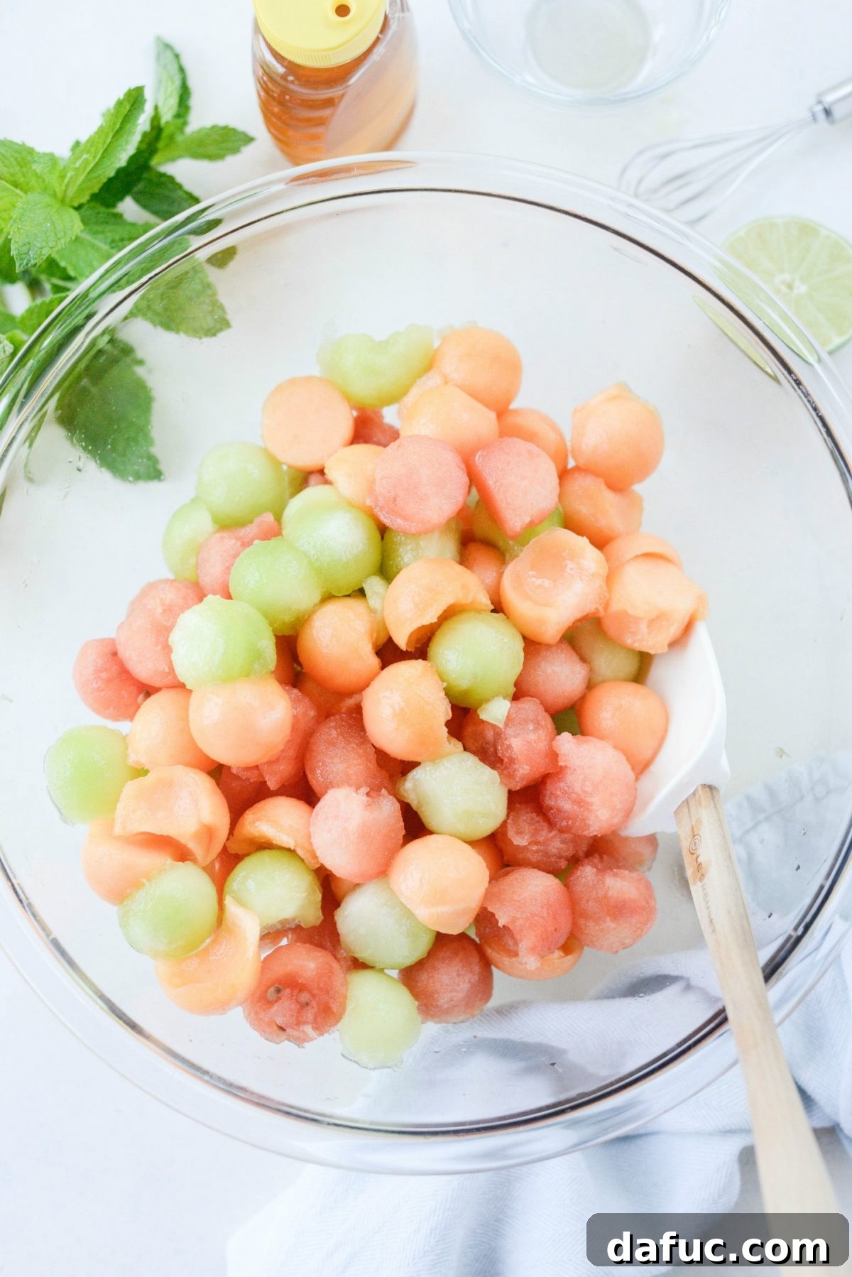 Honey Lime Mint Melon Delight 7 Melon Salad with Honey Lime and Mint, freshly tossed and glistening