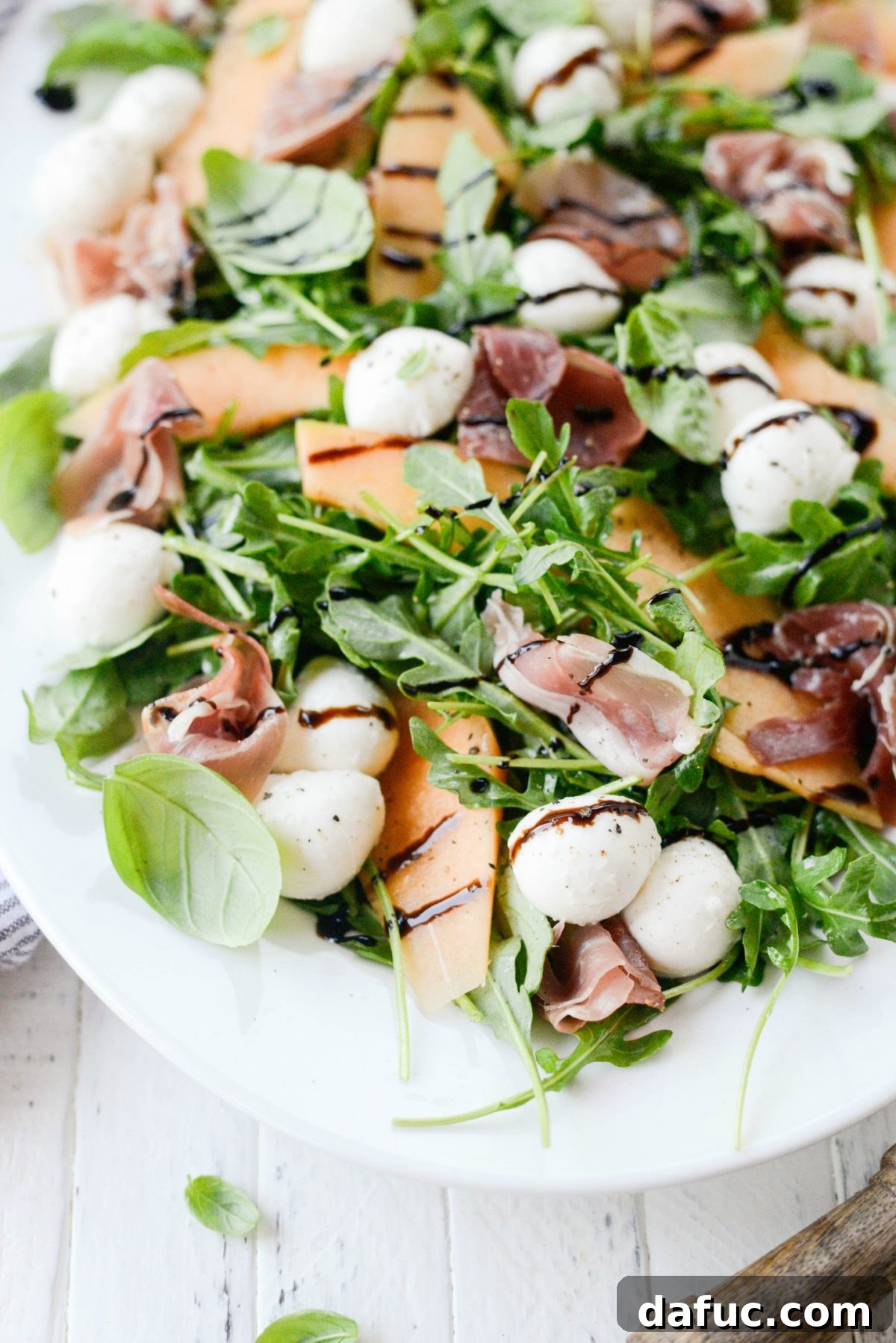 Golden Melon Prosciutto Arugula Fresca 9 A close-up of a single serving of Cantaloupe and Prosciutto Arugula Caprese Salad, showcasing the layers of flavor