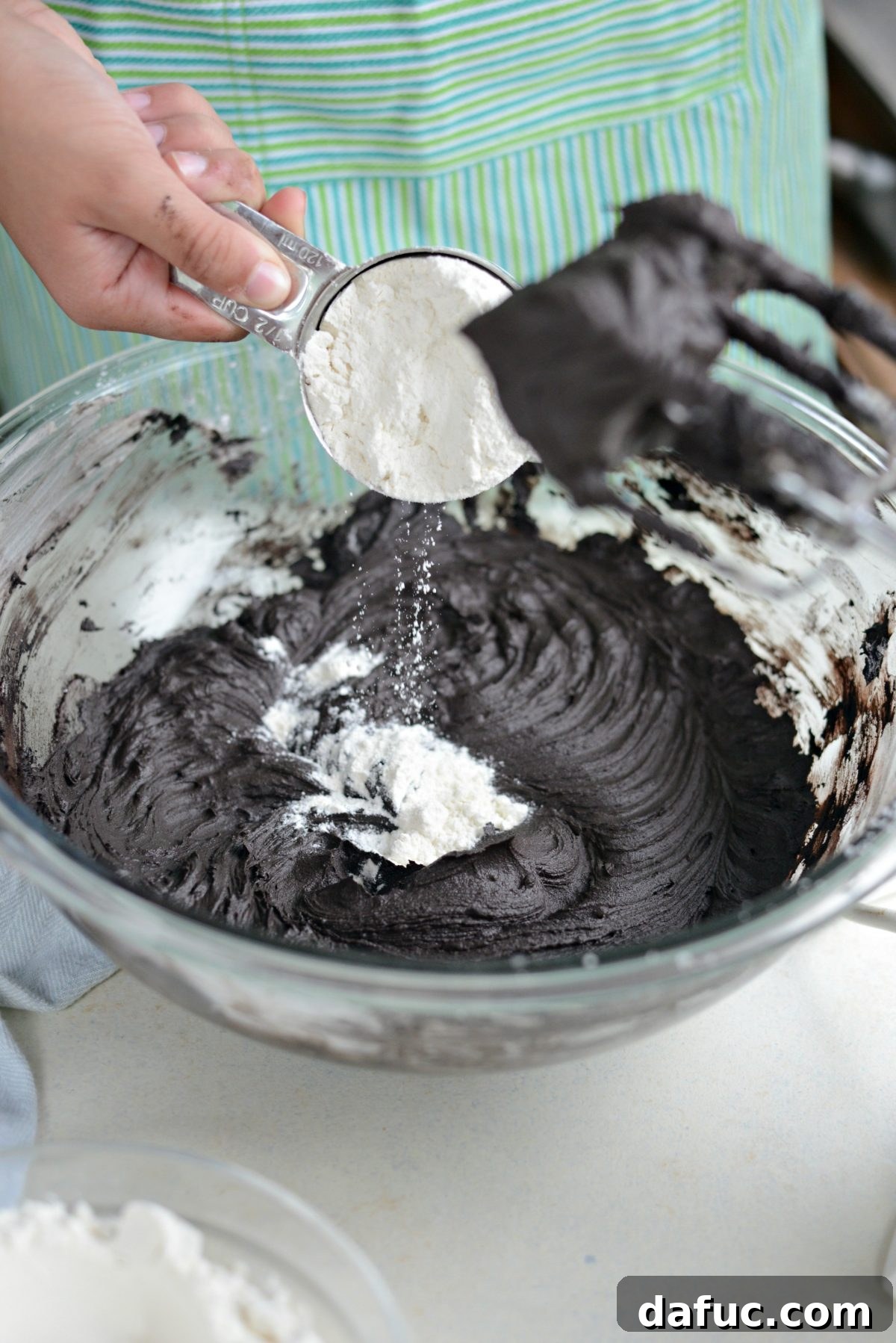 Adding flour to the cookie dough mixture