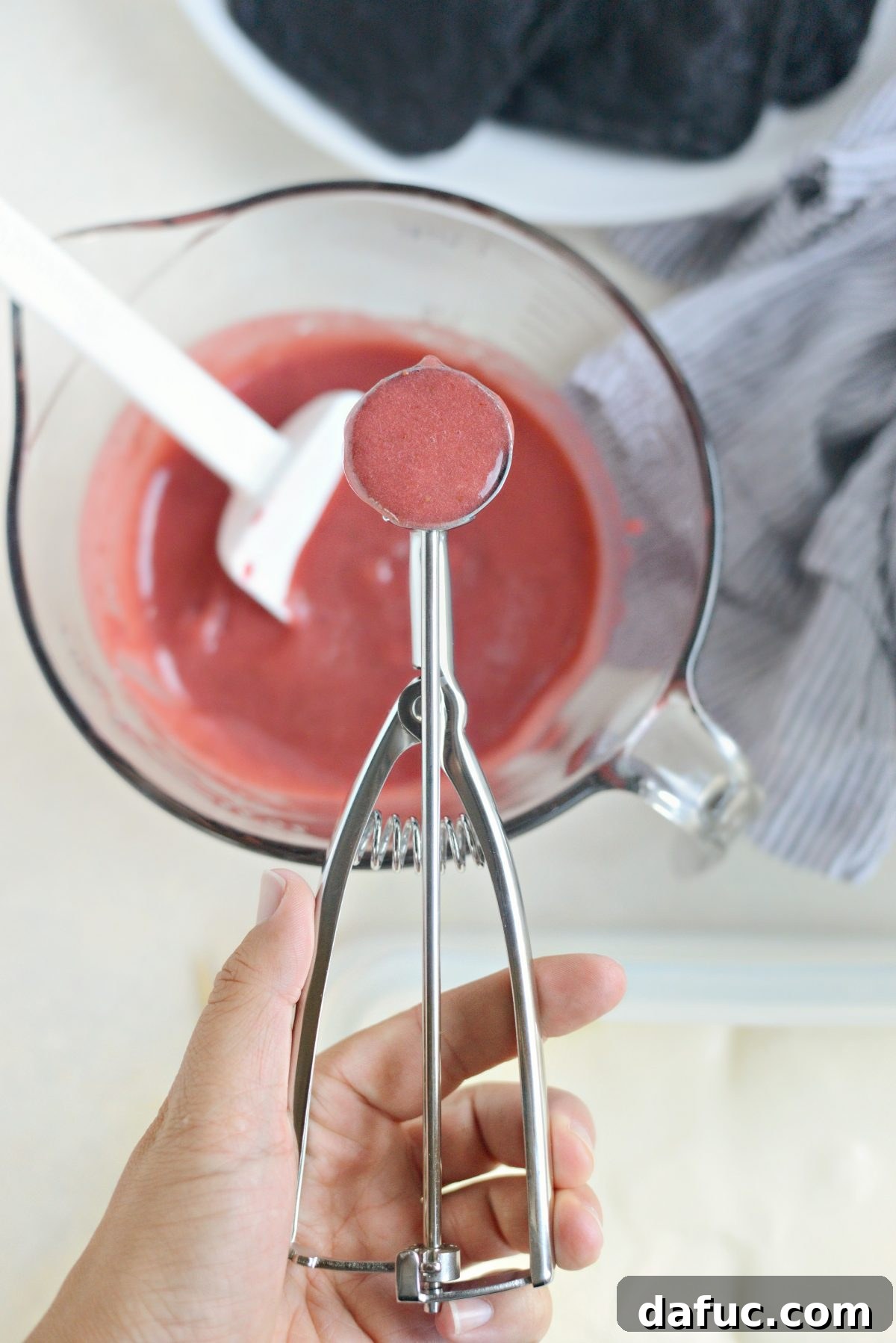 Drizzling strawberry puree over ice cream
