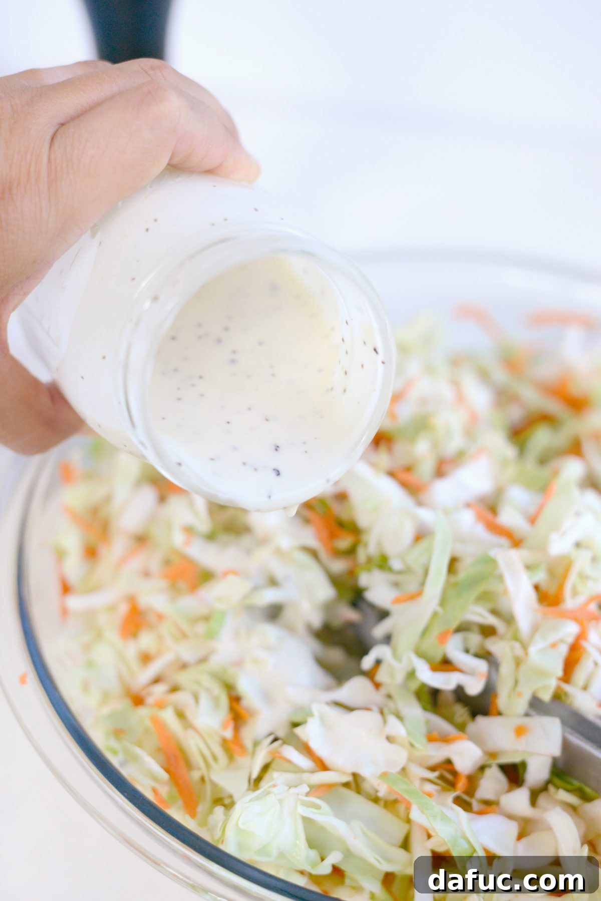 Perfect Classic Coleslaw From Scratch 12 Pouring homemade coleslaw dressing over shredded cabbage and carrots