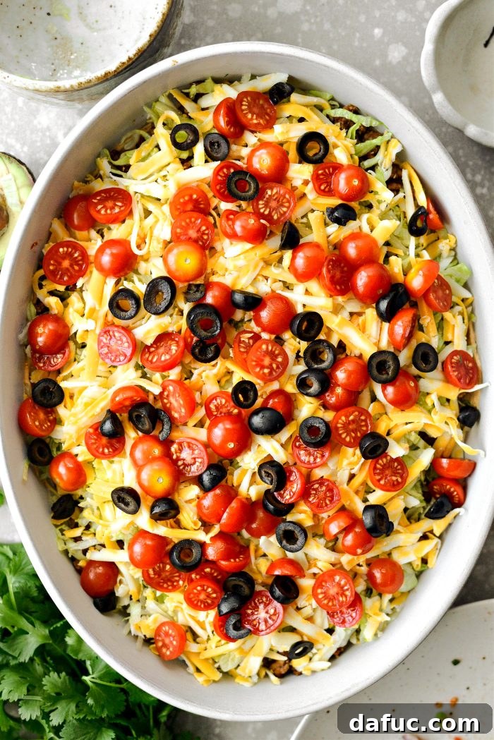 Fiesta Seven Layer Taco Dip 12 Adding Shredded Lettuce, Cheese, Tomatoes, and Olives