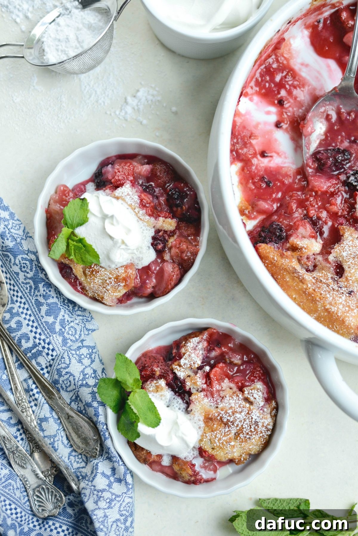 Close-up of served Triple Berry Cobbler garnished with mint.