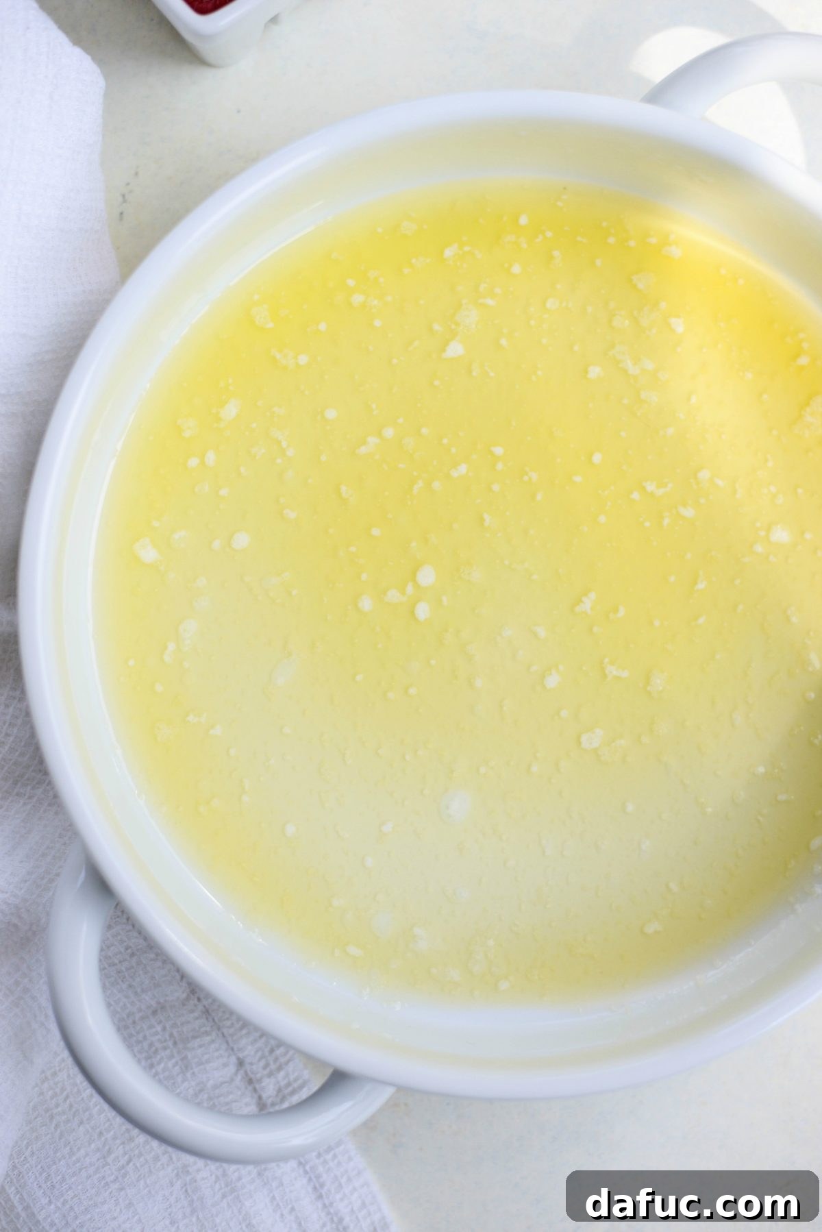 Melted butter poured into a clear glass baking dish.