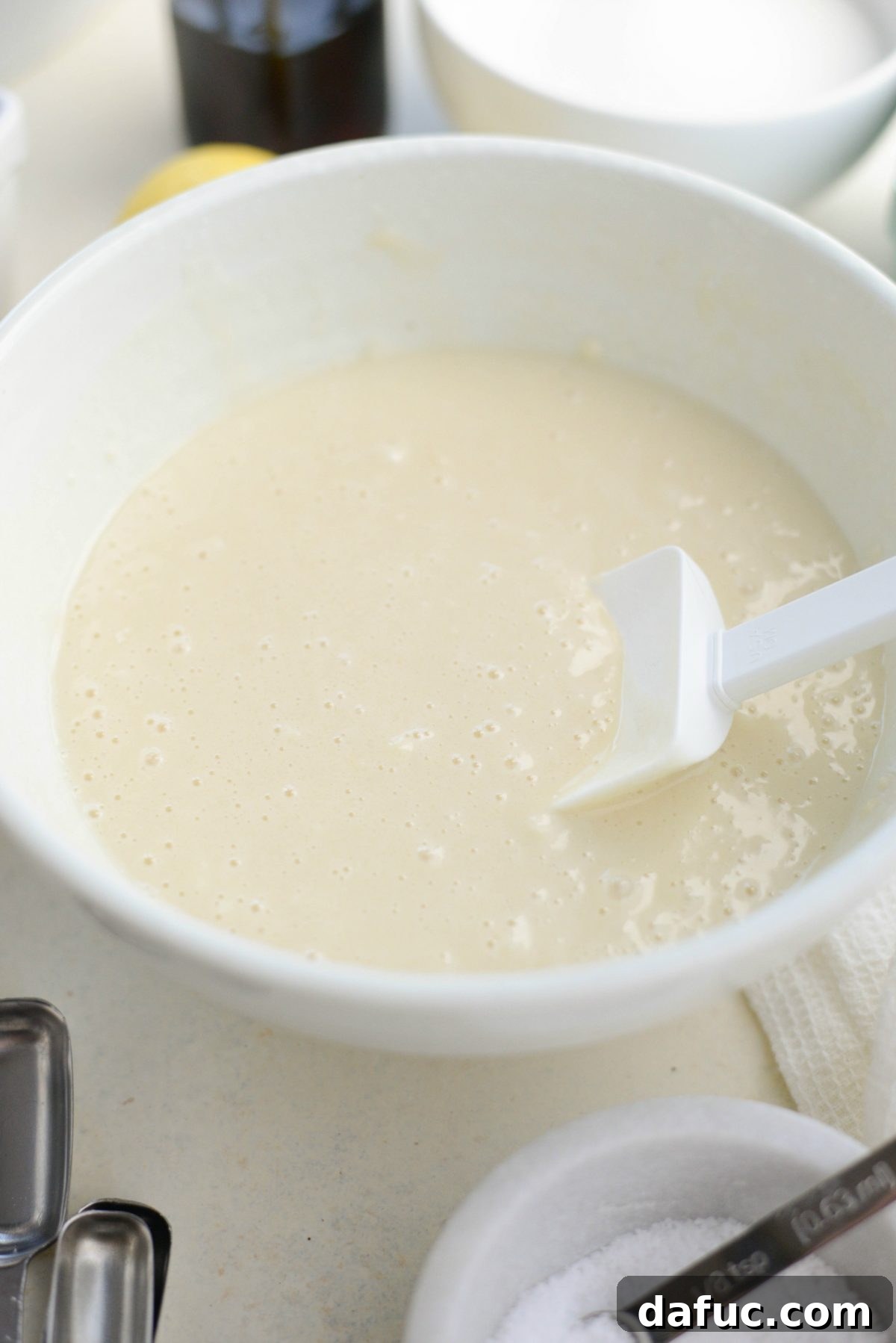 Wet and dry ingredients for cobbler batter mixed in a bowl.