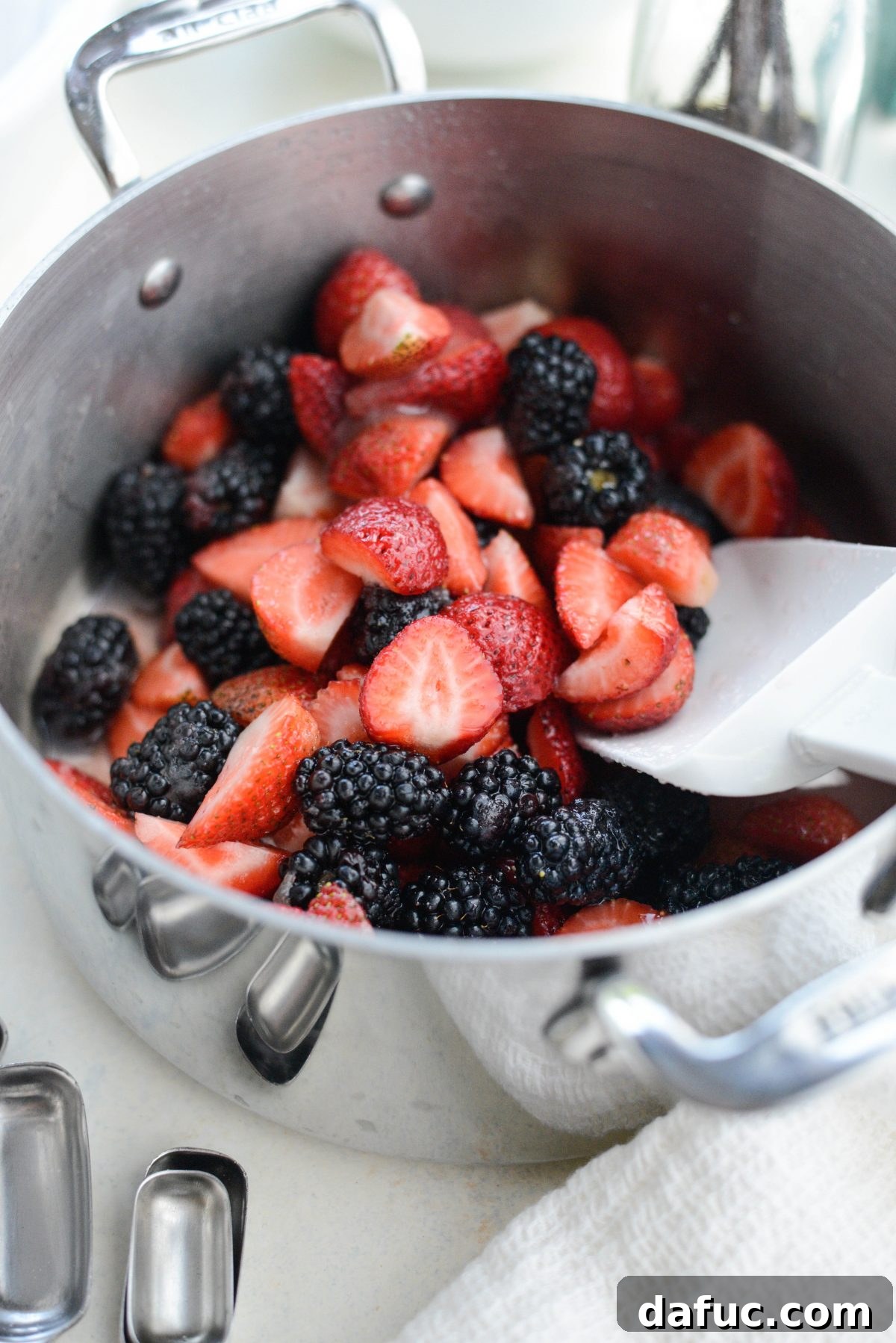 Berries heating in a saucepan to release juices.