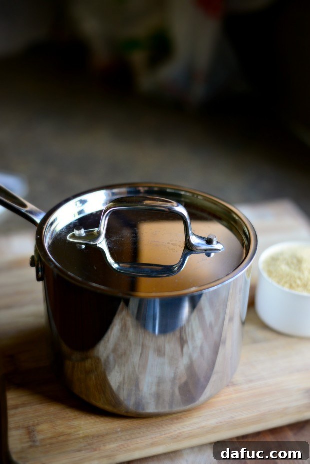 Mastering Fluffy Couscous in Minutes 5 Adding olive oil to water in a saucepan for couscous