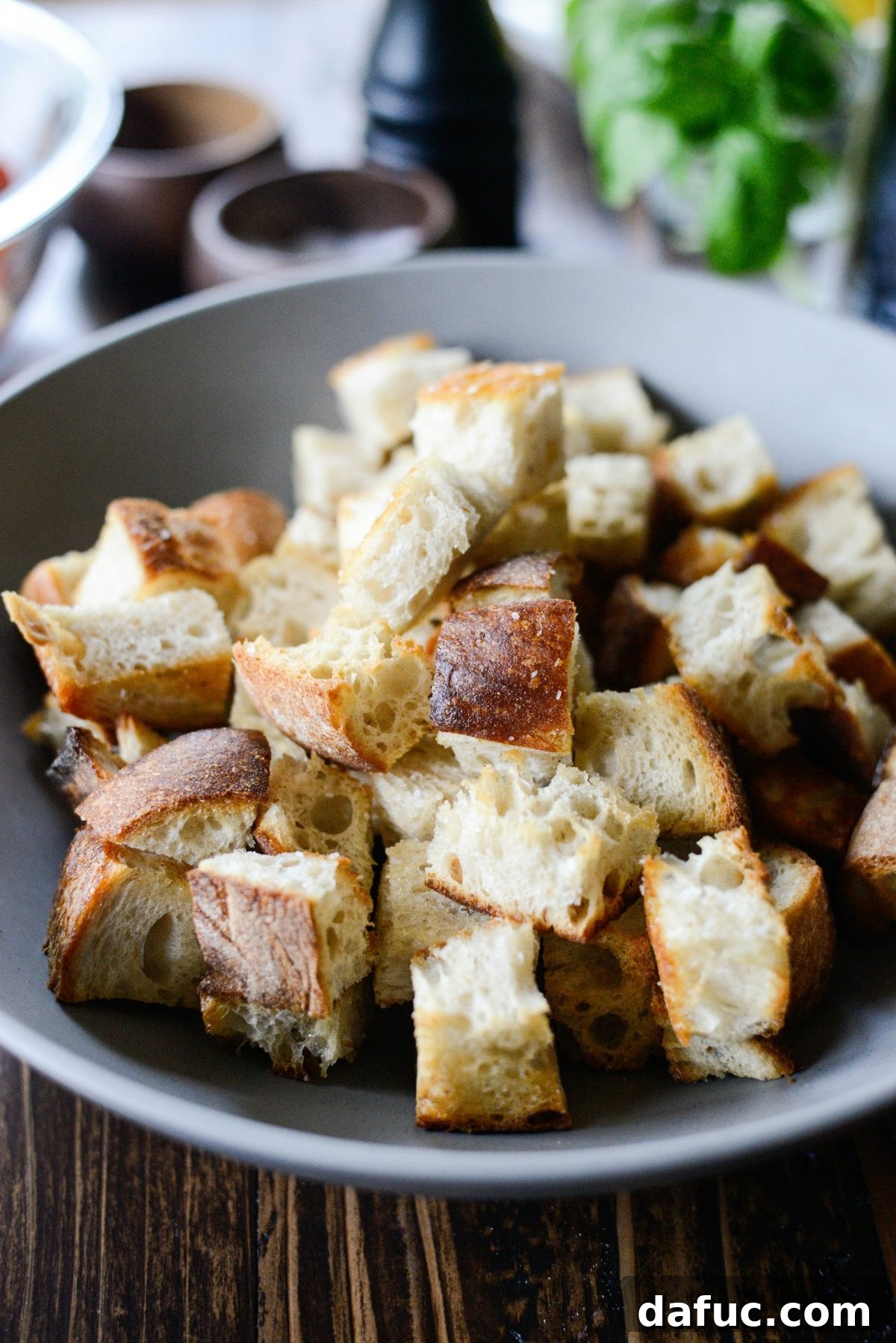 Warm, toasted cubed bread in a large serving bowl, ready for the tomato mixture