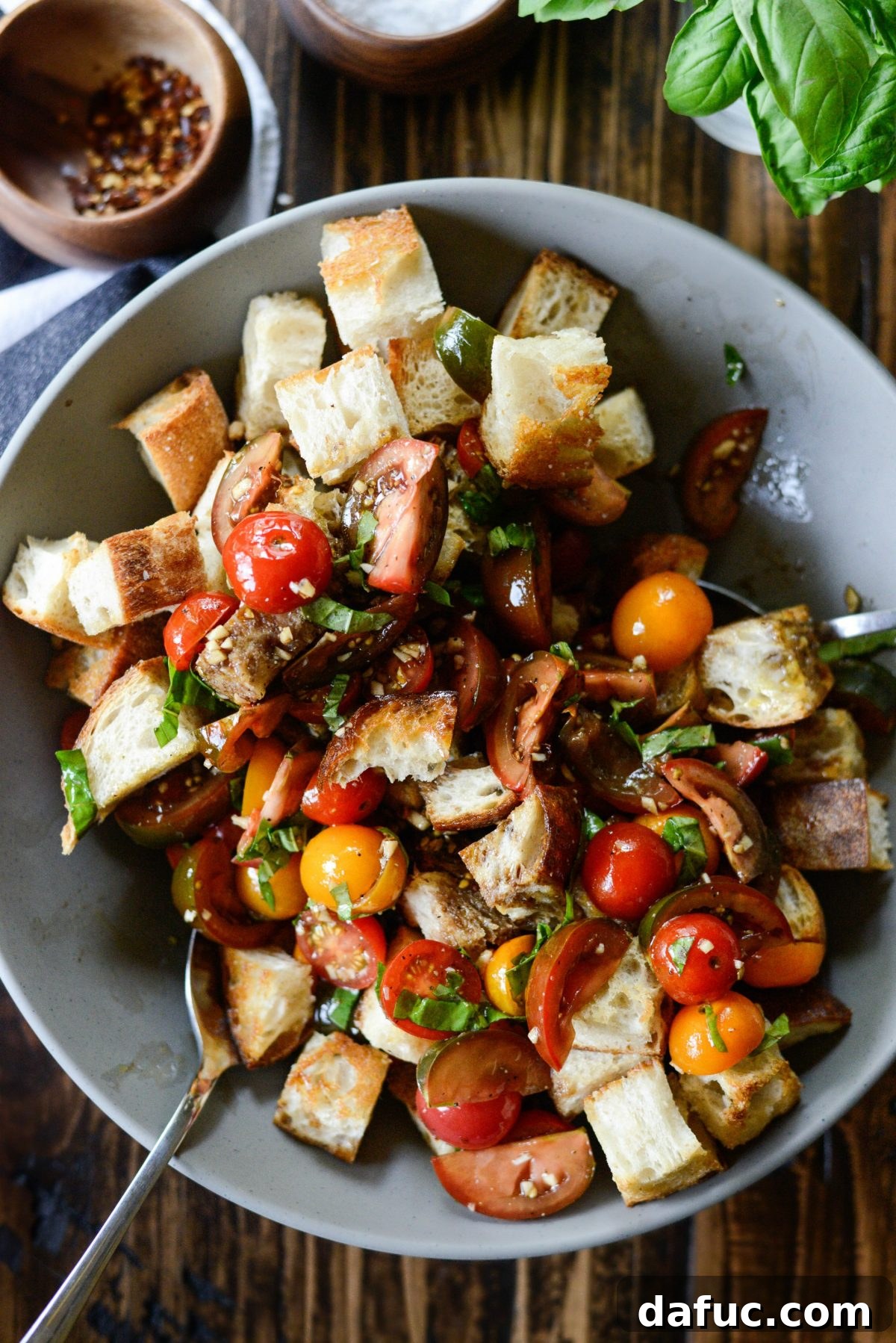 Tossing the Tomato Bruschetta Panzanella to combine all ingredients, ensuring bread is coated