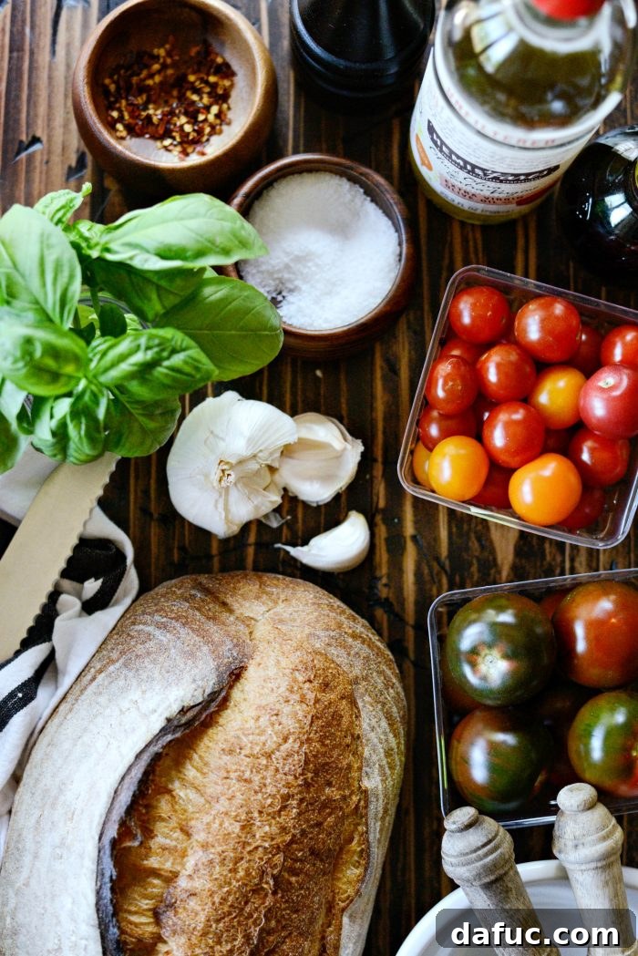 Fresh ingredients for Tomato Bruschetta Panzanella: ripe tomatoes, basil, garlic, and crusty bread