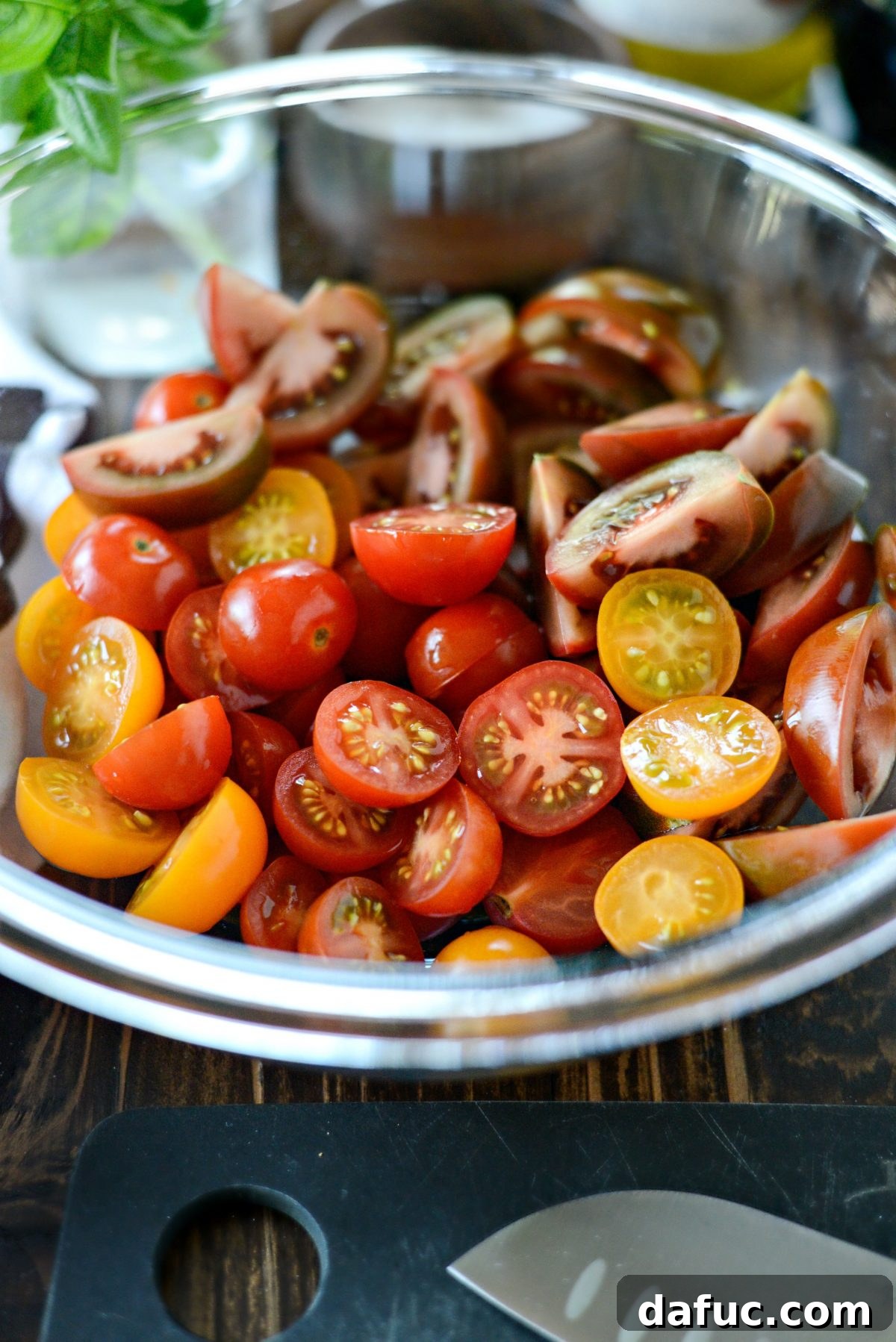 Freshly halved and quartered tomatoes in a bowl, ready for marinating