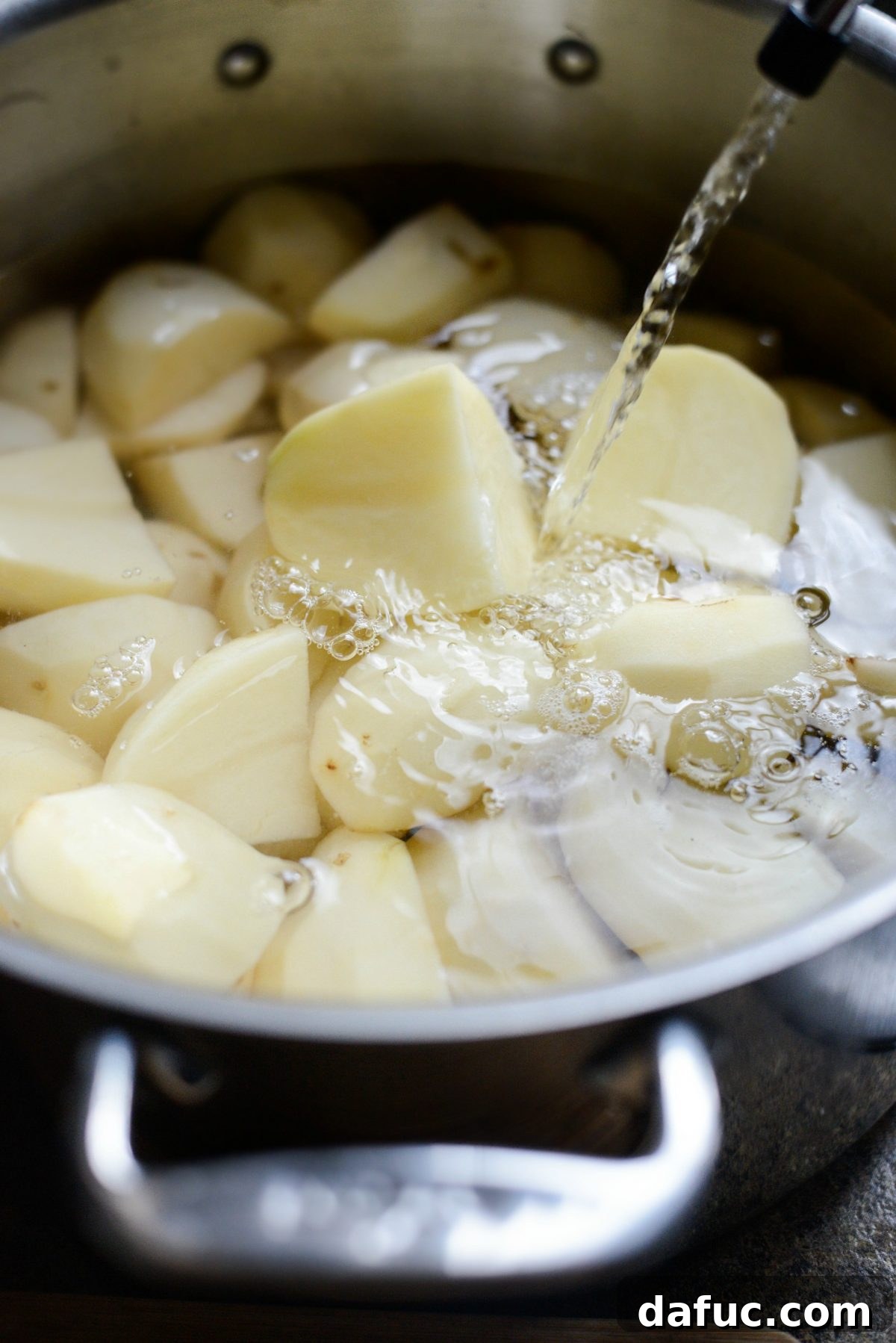 Potatoes covered with water in a pot, boiling on the stove.