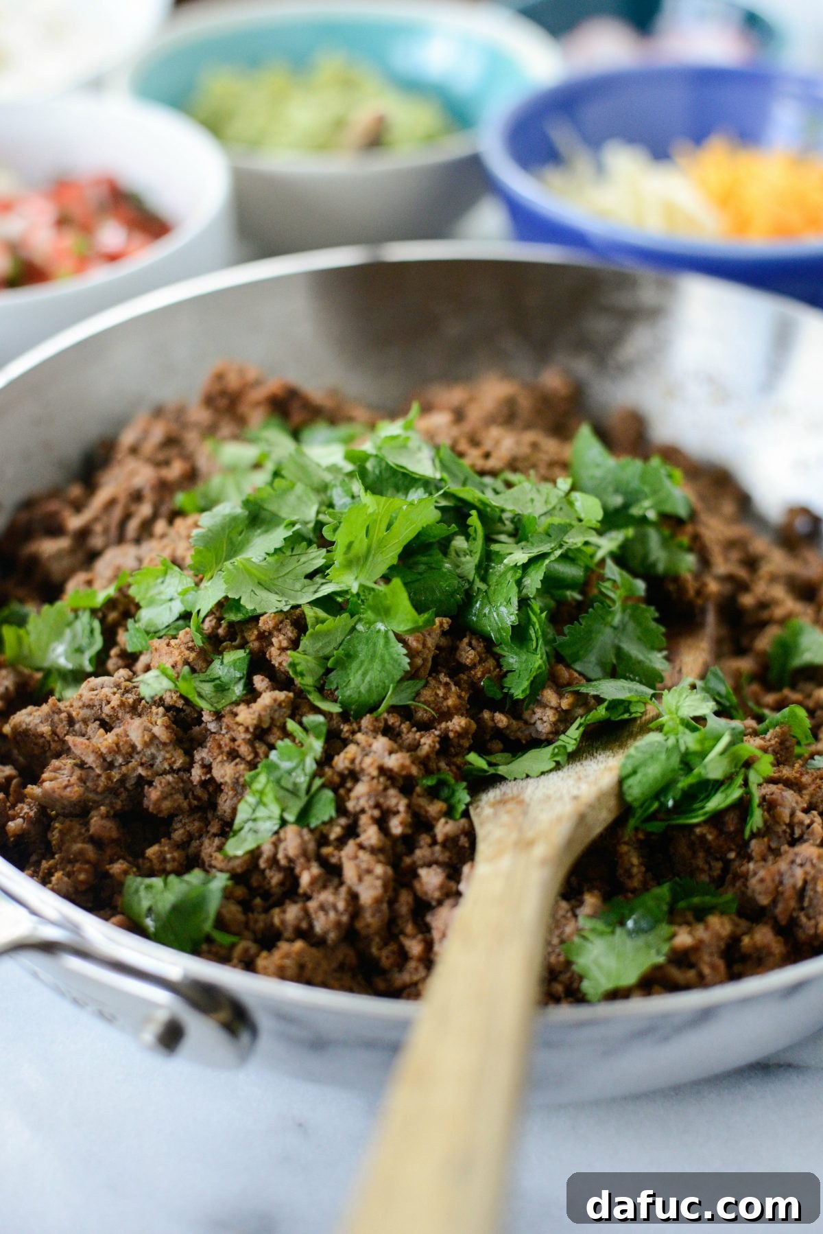 Beefy Bean Burrito Bowls 4 Adding fresh cilantro to cooked ground beef for flavor