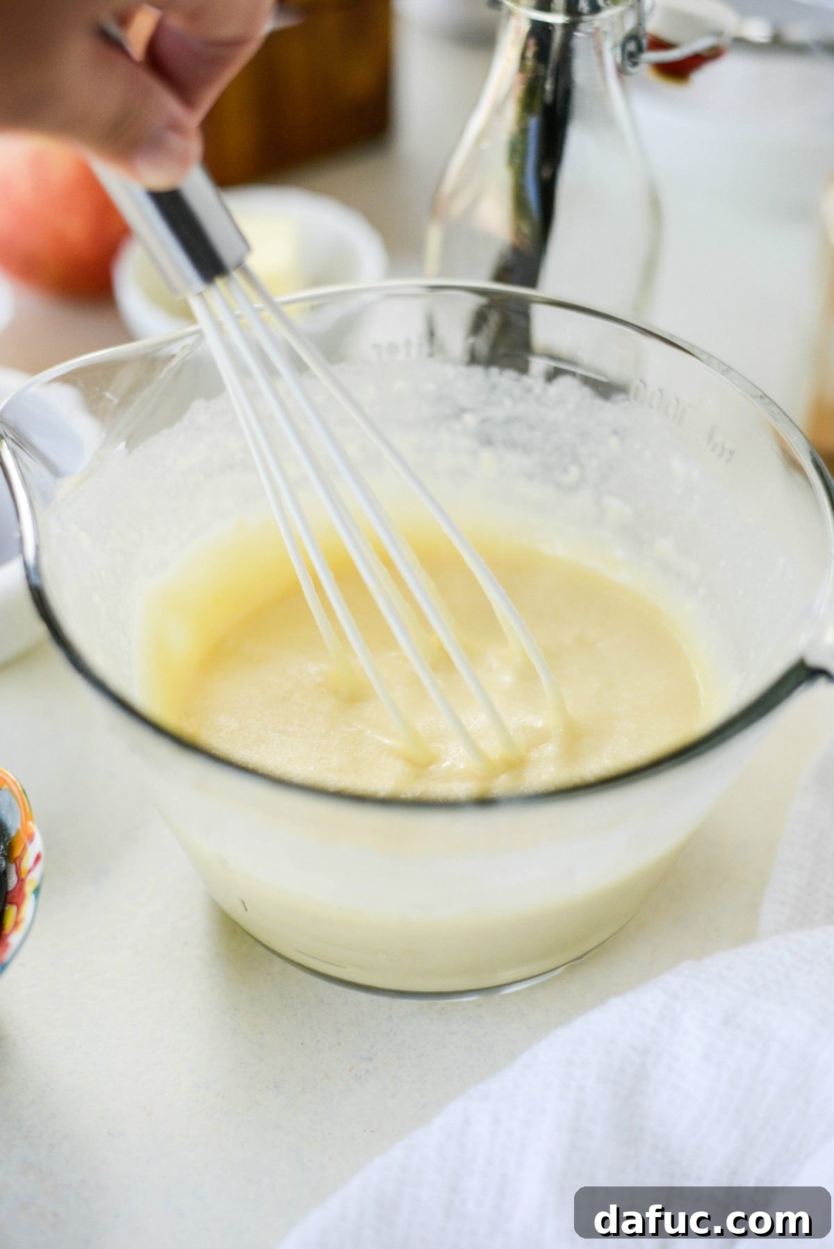 Sweet Caramel Apple Skillet Puff 6 Whisking Dutch Baby batter in a mixing bowl until smooth.